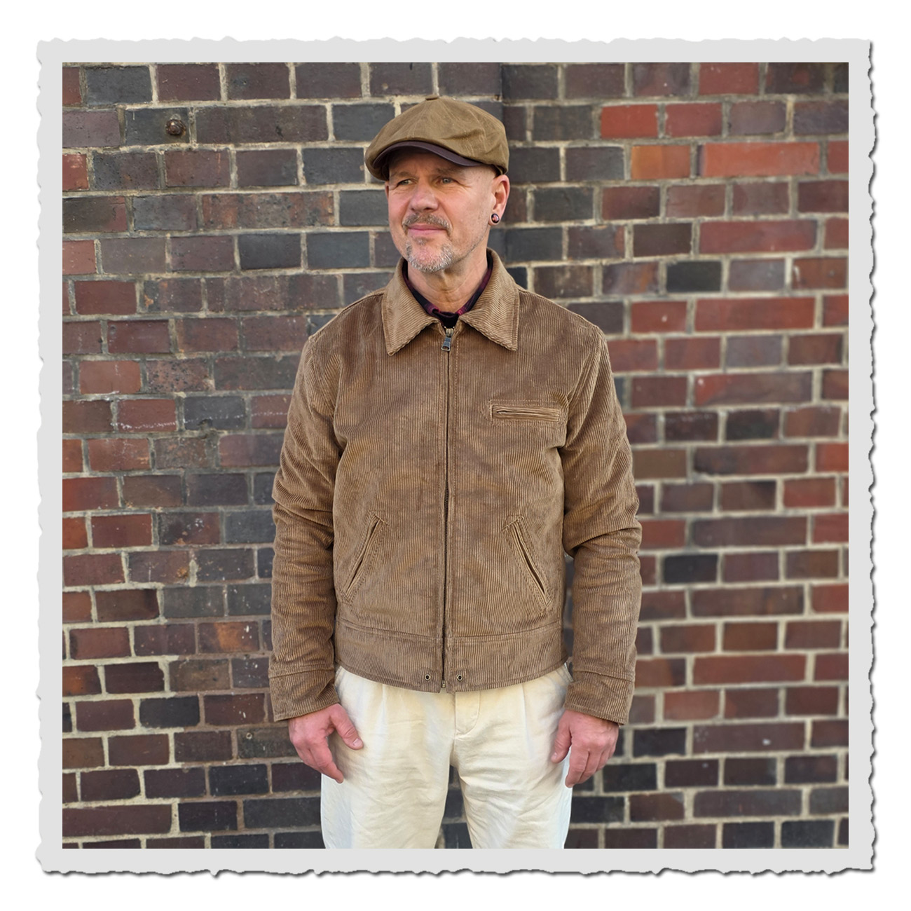 Mann vor Ziegelwand trägt Pike Brothers 1932 Roadster Jacket Light Brass Cord – klassische Cordjacke im Vintage-Stil